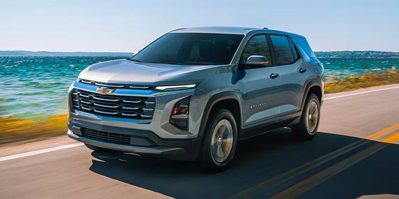 Chevrolet Equinox SUV driving along a coastal road with modern exterior styling.