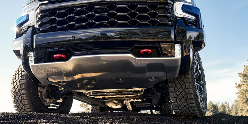Chevrolet Silverado truck front bumper, grille, and off-road tires showcasing rugged exterior design.